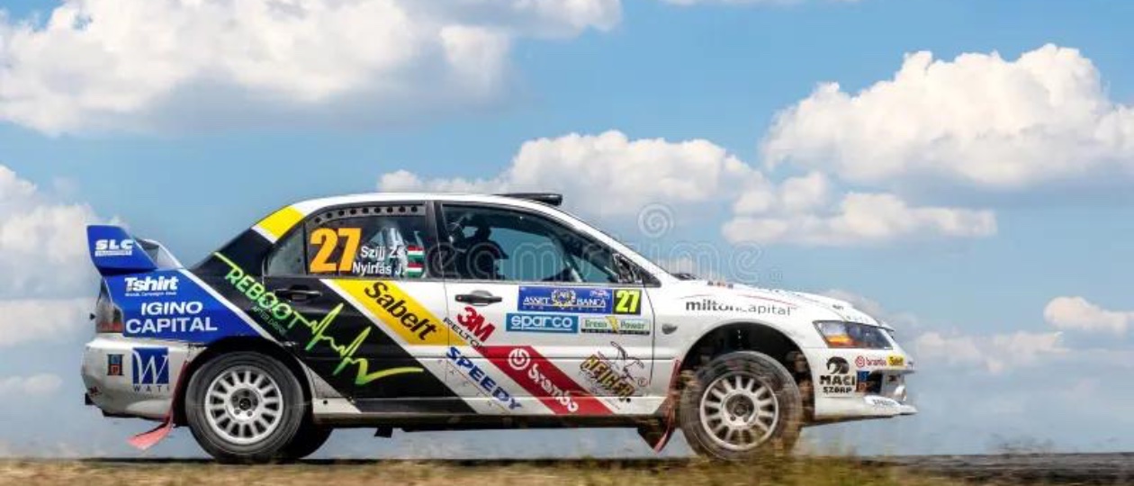 A white Mitsubishi Lancer Evolution IX MR on a rally track